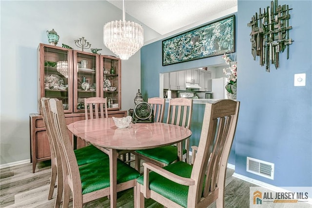 dining area with a chandelier and light hardwood / wood-style floors