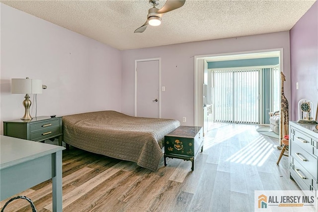 bedroom with a textured ceiling, ceiling fan, and light wood-type flooring