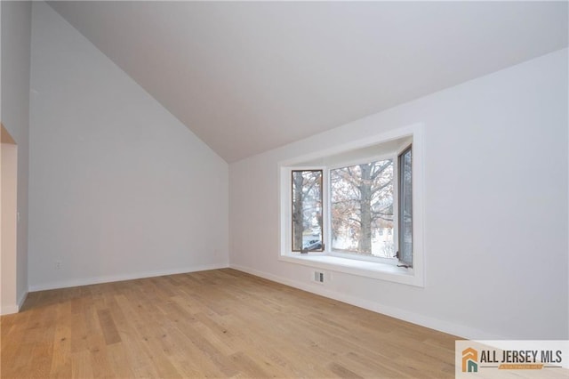 additional living space featuring lofted ceiling and light wood-type flooring