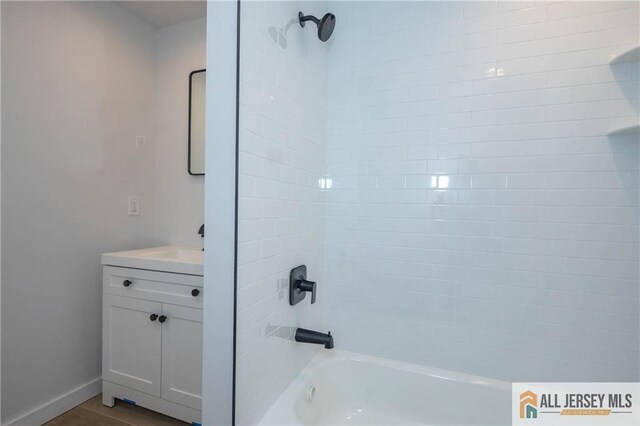 bathroom featuring vanity and tiled shower / bath