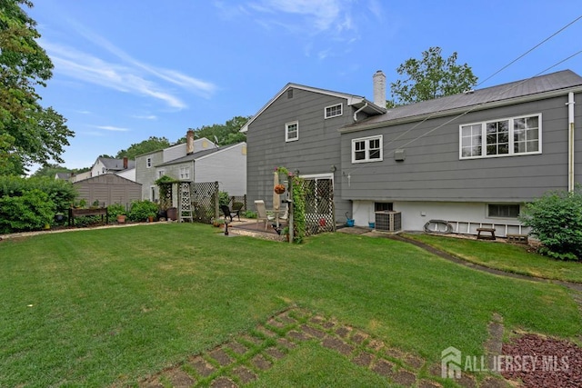 38 Foothills Dr, South River, NJ 08882 - back of house with central air condition unit, a yard, and a chimney