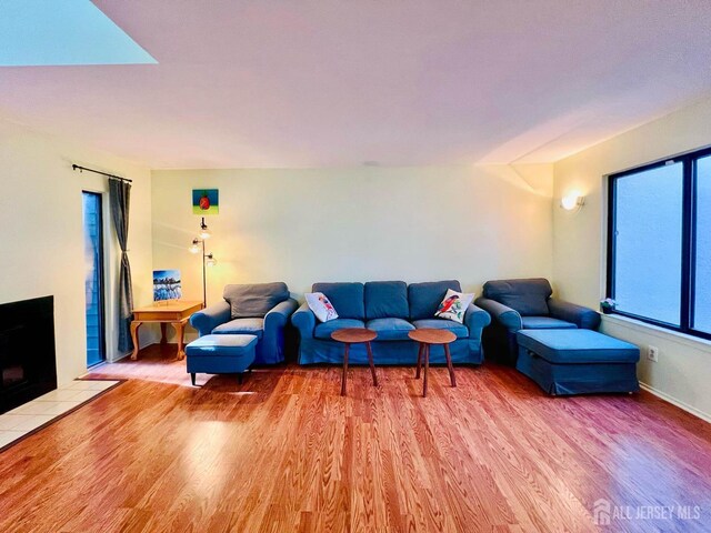 172 Sayre Dr, Plainsboro, NJ 08540 - living area with light wood finished floors, a tiled fireplace, and baseboards