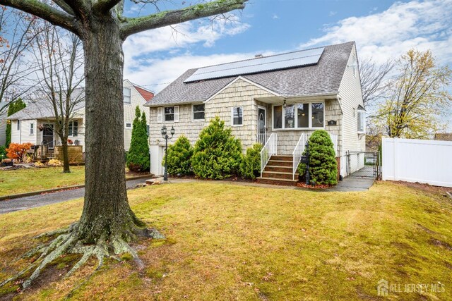 view of front of house featuring a front lawn and solar panels