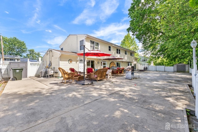15 Creighton Cir, Old Bridge, NJ 08857 - rear view of property with a patio area, a storage unit, and an outdoor hangout area