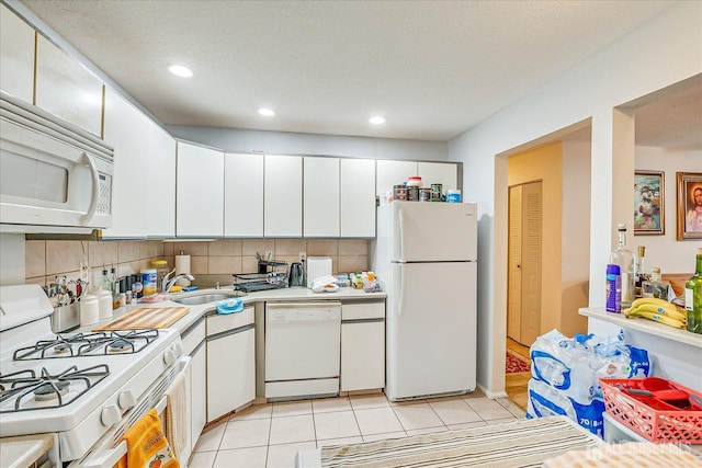 kitchen featuring light tile patterned floors, white appliances, a sink, light countertops, and tasteful backsplash