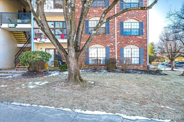 exterior space featuring brick siding and stairs