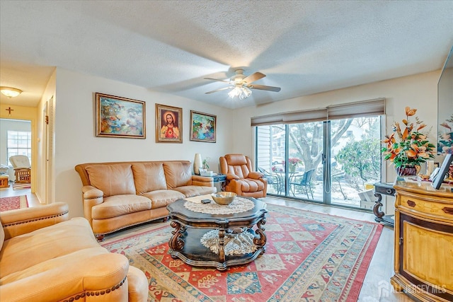 living room featuring a ceiling fan and a textured ceiling