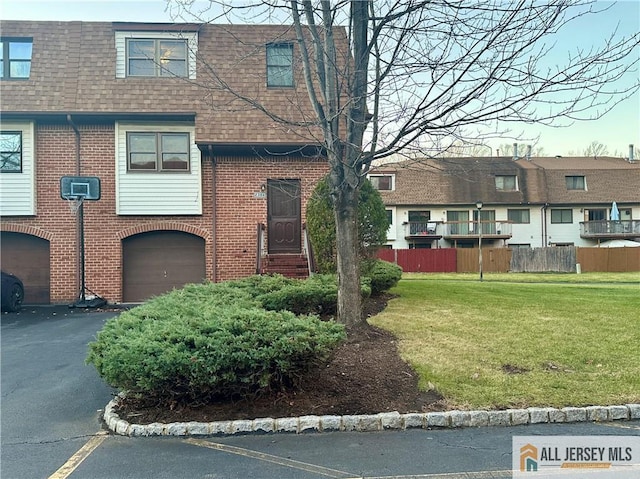 view of property with a garage and a front lawn