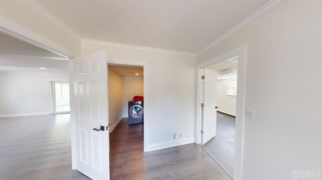 hallway featuring washer / clothes dryer, dark wood-type flooring, and ornamental molding