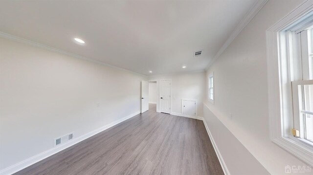 unfurnished room featuring crown molding and wood-type flooring