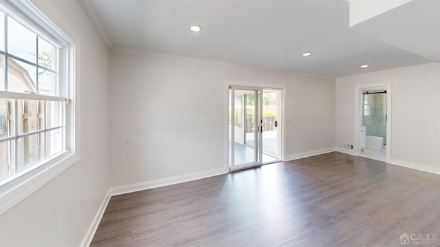 empty room with dark hardwood / wood-style floors and crown molding