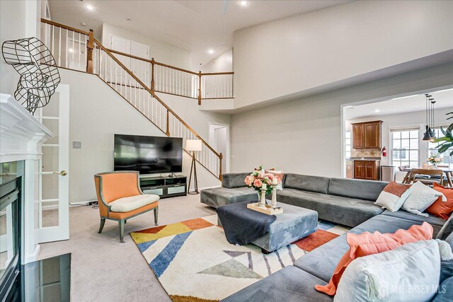 37 Equestrian Way, Monroe, NJ 08831 - living room featuring stairs, light colored carpet, a high ceiling, recessed lighting, and a fireplace