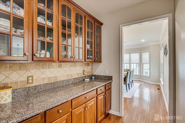 37 Equestrian Way, Monroe, NJ 08831 - kitchen featuring stone counters, light wood-style flooring, tasteful backsplash, glass insert cabinets, and baseboards