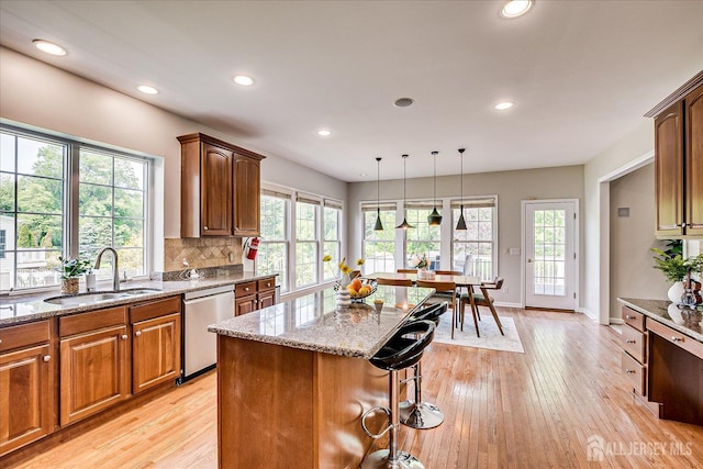 37 Equestrian Way, Monroe, NJ 08831 - kitchen featuring stainless steel dishwasher, a sink, light stone countertops, light wood finished floors, and a breakfast bar area