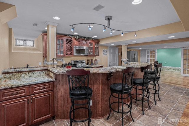 9 Narrow Brook Ct, Plainsboro, NJ 08536 - kitchen with stainless steel appliances, decorative columns, glass insert cabinets, a kitchen bar, and recessed lighting