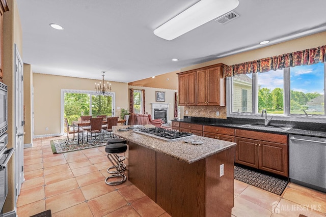 9 Narrow Brook Ct, Plainsboro, NJ 08536 - kitchen with appliances with stainless steel finishes, a sink, brown cabinets, a center island, and light tile patterned floors