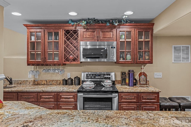 9 Narrow Brook Ct, Plainsboro, NJ 08536 - kitchen with appliances with stainless steel finishes, glass insert cabinets, light stone countertops, recessed lighting, and a sink