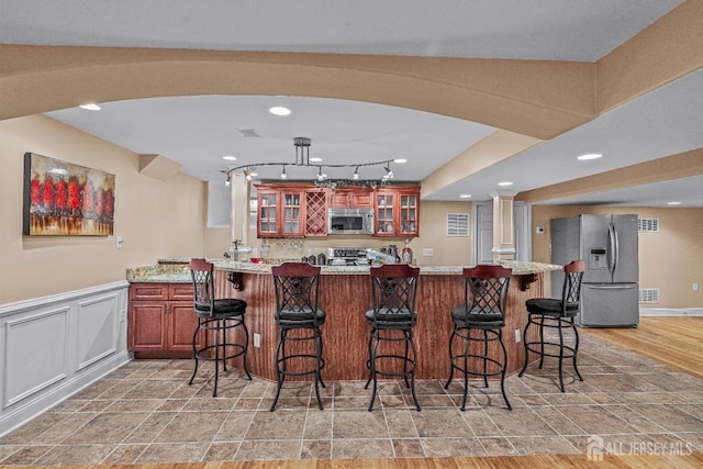 9 Narrow Brook Ct, Plainsboro, NJ 08536 - kitchen featuring stainless steel appliances, glass insert cabinets, a breakfast bar area, light stone finish floors, and recessed lighting