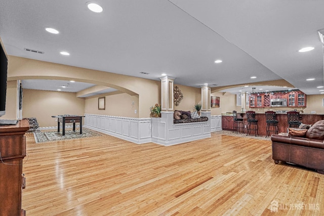 9 Narrow Brook Ct, Plainsboro, NJ 08536 - living room featuring a community bar, light wood-type flooring, recessed lighting, arched walkways, and decorative columns