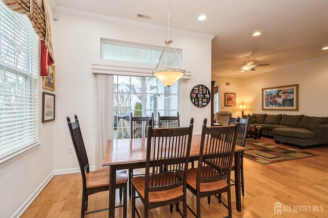 dining room featuring light wood-type flooring, ceiling fan, and ornamental molding