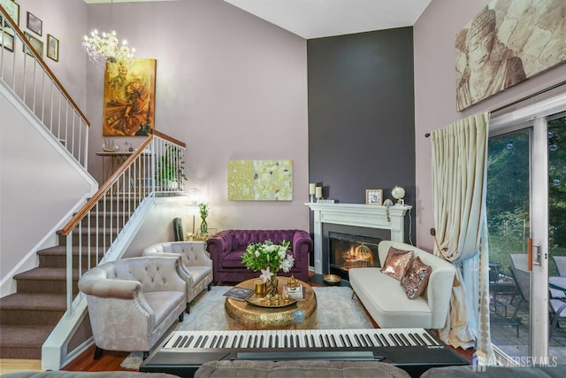 82 Heather Ct, South Brunswick, NJ 08852 - living area with stairs, a towering ceiling, a chandelier, and a warm lit fireplace