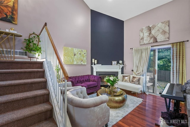 82 Heather Ct, South Brunswick, NJ 08852 - living room featuring stairs, dark wood finished floors, a towering ceiling, and a fireplace