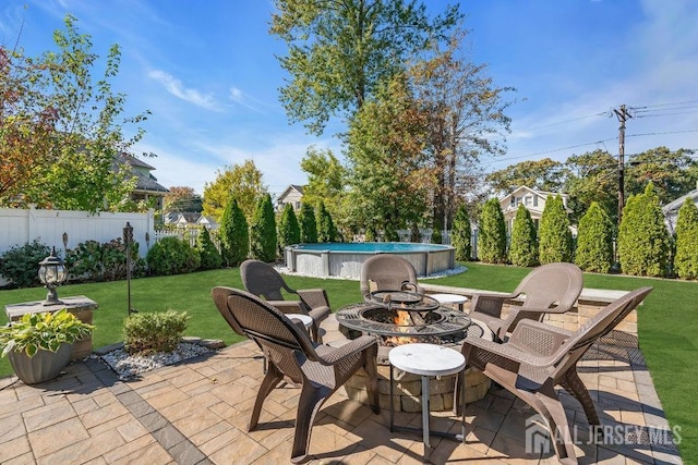 view of patio / terrace featuring fence, a fire pit, and a fenced in pool