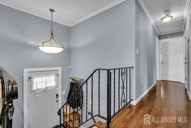 foyer with ornamental molding, baseboards, and wood finished floors