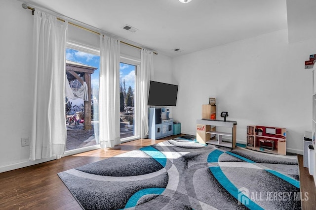 interior space with visible vents, baseboards, and wood finished floors