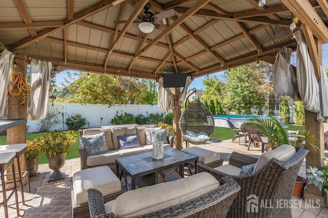 view of patio featuring a gazebo, a swimming pool, an outdoor living space, and a fenced backyard