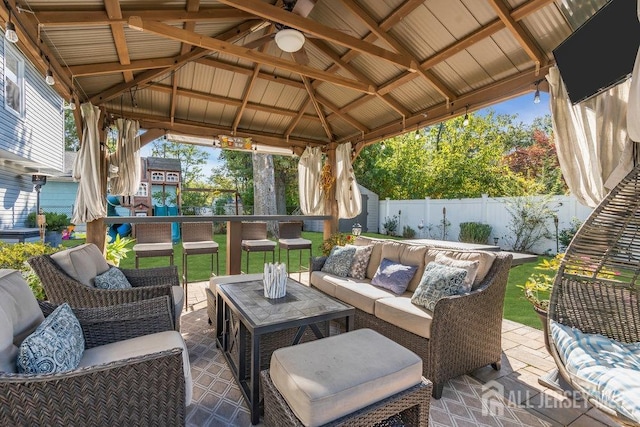 view of patio featuring a gazebo, an outdoor hangout area, and a fenced backyard