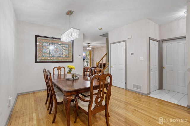 1905 Dahlia Cir S, Brunswick, NJ 08810 - dining room featuring light wood finished floors, stairway, a ceiling fan, and a chandelier