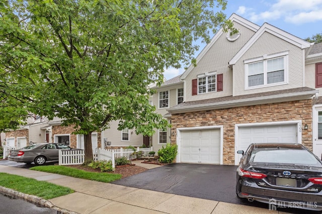 1905 Dahlia Cir S, Brunswick, NJ 08810 - townhome / multi-family property with stone siding, asphalt driveway, and an attached garage