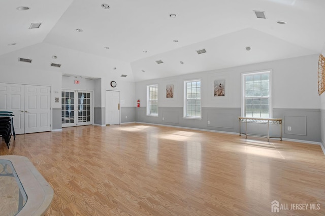 1905 Dahlia Cir S, Brunswick, NJ 08810 - unfurnished living room with a wainscoted wall, light wood-style floors, french doors, healthy amount of natural light, and high vaulted ceiling