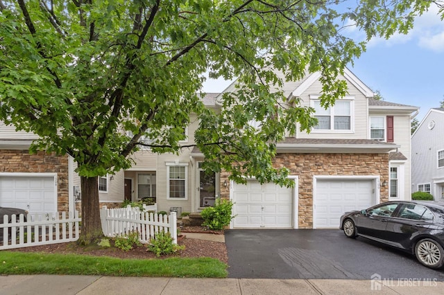 1905 Dahlia Cir S, Brunswick, NJ 08810 - view of front of property with stone siding, asphalt driveway, and a garage