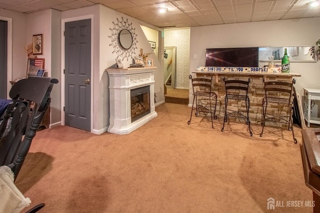 20 N Shore Blvd Unit B, Helmetta, NJ 08828 - living room featuring carpet flooring, a bar, stairs, a glass covered fireplace, and a drop ceiling