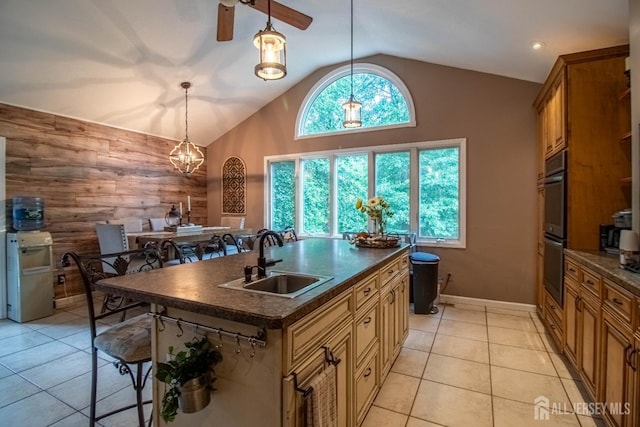 20 N Shore Blvd Unit B, Helmetta, NJ 08828 - kitchen with dark countertops, wooden walls, a breakfast bar area, a center island with sink, and high vaulted ceiling