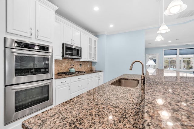 10 E Black Heath Ct, Howell, NJ 07727 - kitchen with appliances with stainless steel finishes, dark stone counters, white cabinetry, decorative backsplash, and crown molding