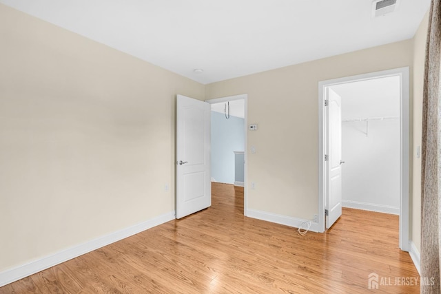 10 E Black Heath Ct, Howell, NJ 07727 - unfurnished bedroom with light wood-style flooring, a walk in closet, and a closet