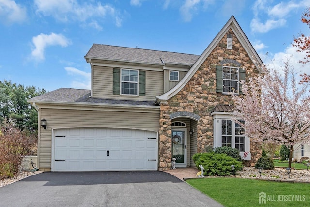 10 E Black Heath Ct, Howell, NJ 07727 - view of front facade featuring driveway, stone siding, and roof with shingles