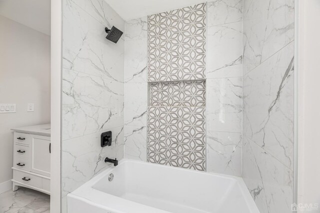 bathroom featuring tiled shower / bath and vanity