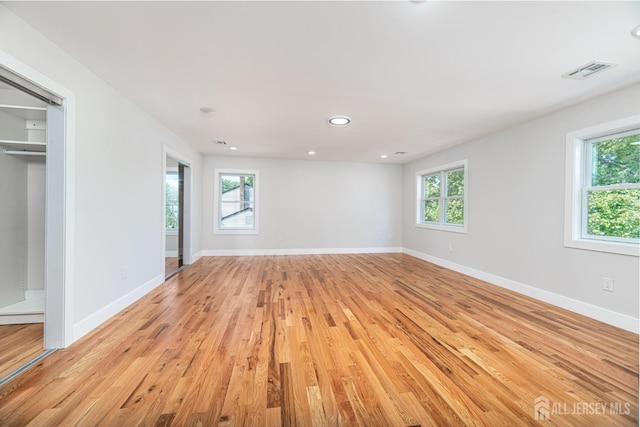 unfurnished bedroom with multiple windows and light hardwood / wood-style floors