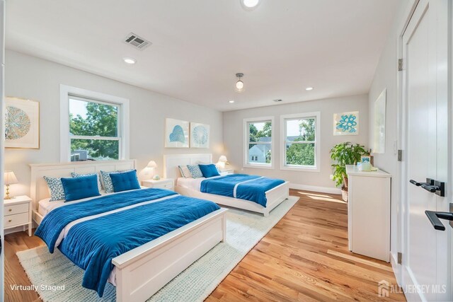 bedroom featuring multiple windows and light hardwood / wood-style floors