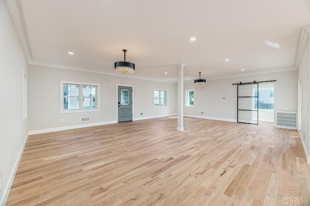 interior space featuring crown molding, a chandelier, light hardwood / wood-style flooring, and ornate columns