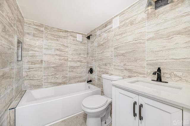 full bathroom featuring tile walls, vanity, bathtub / shower combination, and toilet