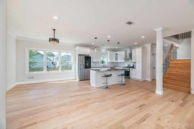 kitchen with pendant lighting, a breakfast bar area, white cabinets, and a kitchen island