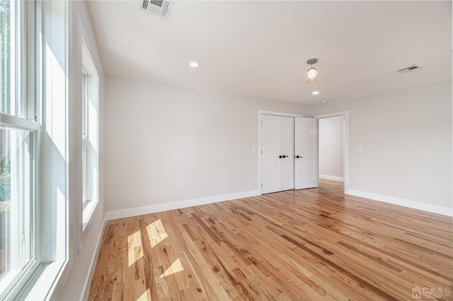 spare room with plenty of natural light and light hardwood / wood-style floors