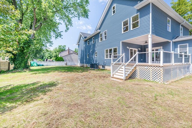 rear view of house with a wooden deck, central AC, ceiling fan, and a lawn