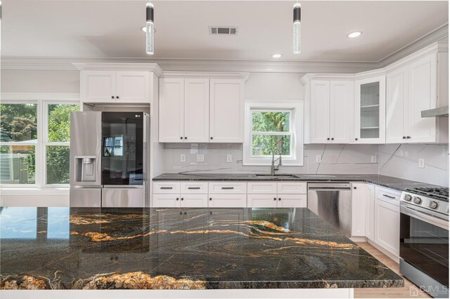 kitchen with pendant lighting, sink, stainless steel appliances, and white cabinets