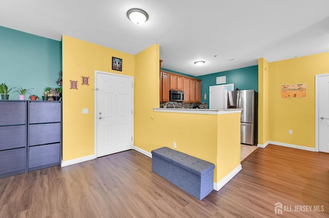 2022 Edward Stec Blvd, Edison, NJ 08837 - kitchen with stainless steel appliances, light wood-type flooring, a peninsula, and baseboards